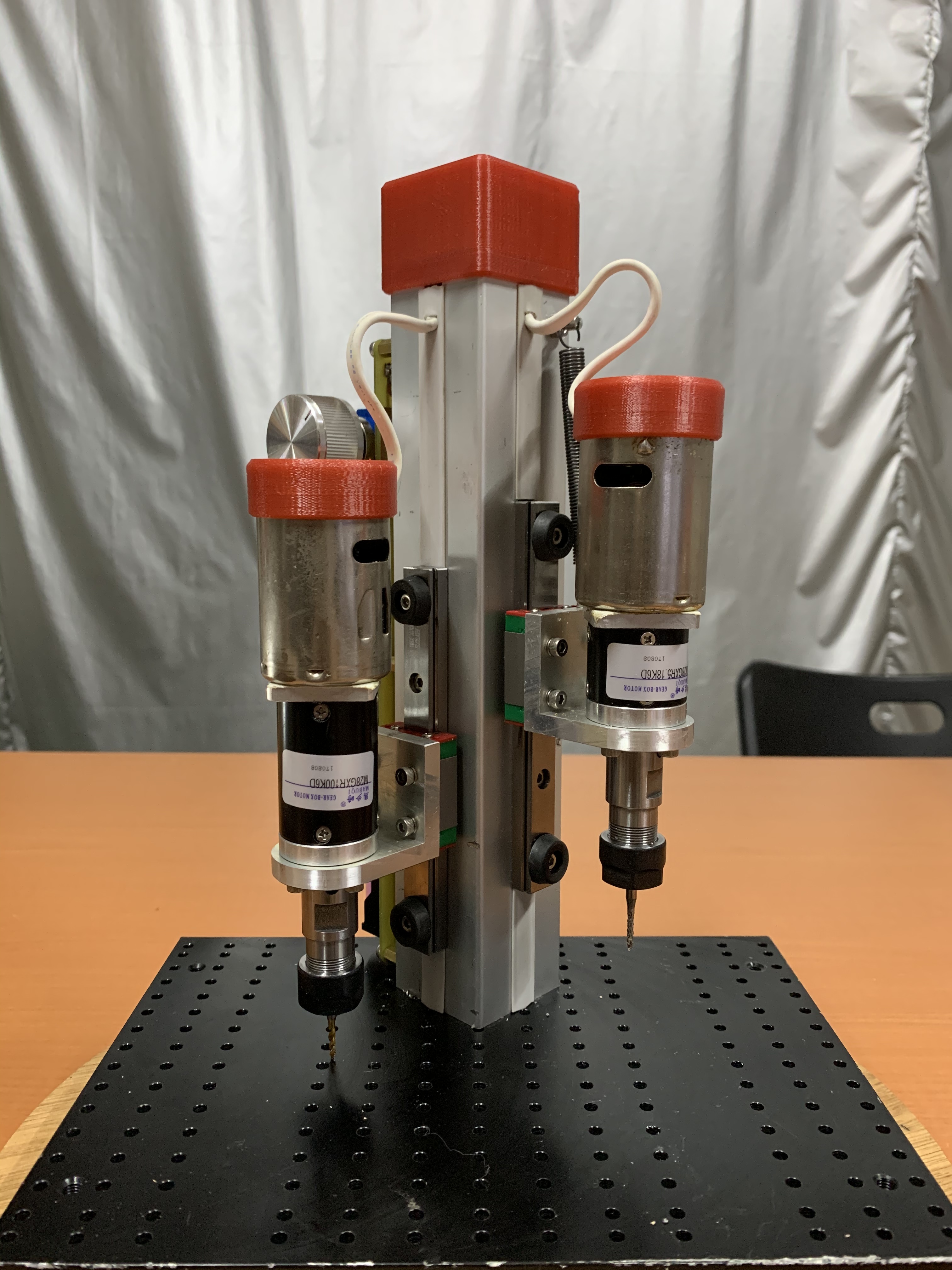 用不同減速比的減速機來搭配,一邊鑽孔,另一邊攻牙。